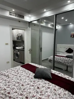 a bedroom with two beds and a mirror at alrabyeh studio 21 استوديو الرابية in Amman