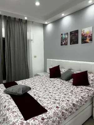 a bedroom with a large bed with red pillows at alrabyeh studio 21 استوديو الرابية in Amman