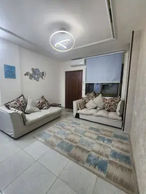 a living room with two white couches and a window at اللجين 6m in Irbid