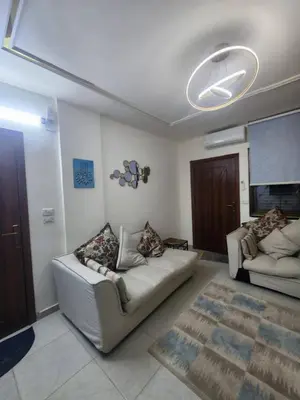 a living room with two couches and a ceiling fan at اللجين 6m in Irbid
