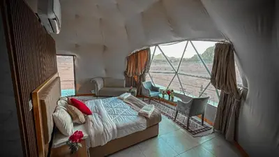 a bedroom with a bed and a large window at wadi rum gem in Disah