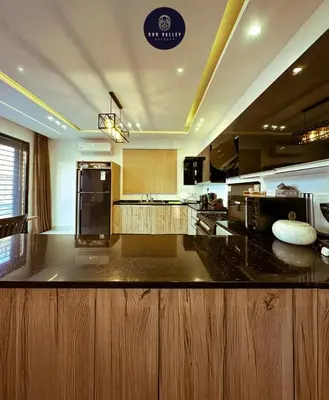a large kitchen with a black counter top at SunValley in Al Rama