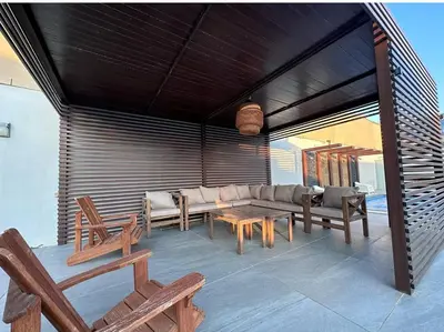 a patio with chairs and a couch and tables at SunValley in Al Rama