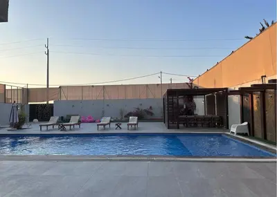 a swimming pool with tables and chairs next to a building at SunValley in Al Rama