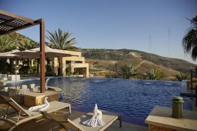 a large swimming pool with chairs and umbrellas at Luxurious private villa in Mahis in Māḩiş