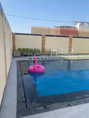 a swimming pool with a pink swan in the water at Nabila Chalet in Sowayma