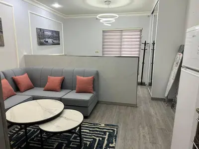 a living room with a couch and two tables at استوديو الجاردنز gardens studio 319 in Al Jafr