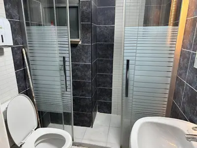 a bathroom with a shower and a toilet and a sink at استوديو الجاردنز gardens studio 319 in Al Jafr