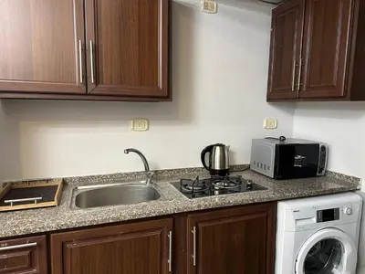 a kitchen with a sink and a microwave at استوديو الجاردنز gardens studio 319 in Al Jafr