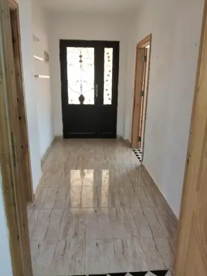 a hallway with a black door and a window at ام الينابيع عجلون in Ajloun