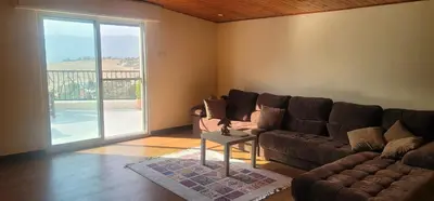 a living room with a couch and a table at Romana in Ar Rummān