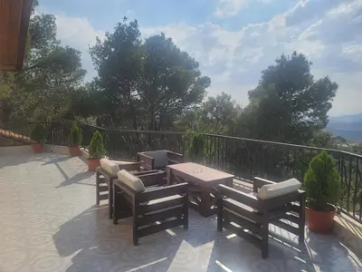 a patio with a table and chairs on a balcony at Romana in Ar Rummān