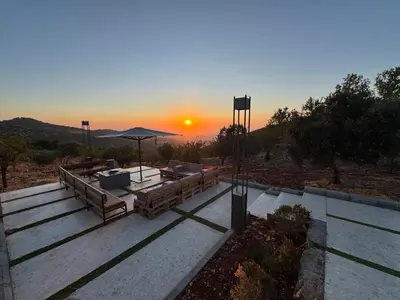 a sunset in the distance with the sun setting at AlFahed Farm in Ajloun
