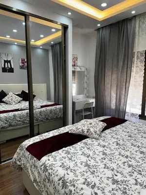 a bedroom with two beds and a mirror at استوديو الرابية 19 studio alrabyeh in Al Jafr