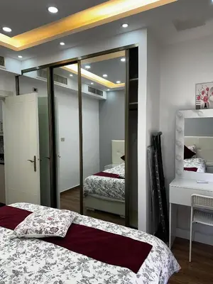 a bedroom with two beds and a mirror at استوديو الرابية 19 studio alrabyeh in Al Jafr