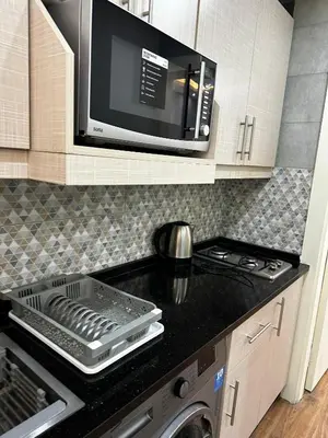 a kitchen with a microwave and a stove and a sink at استوديو الرابية 19 studio alrabyeh in Al Jafr