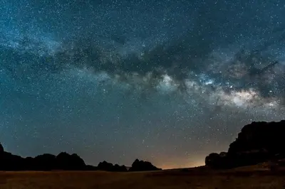 a starry night with the milky way in the sky at Adventure Nights Camp in Wadi Rum
