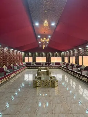 a swimming pool with chairs and a table in a room at Adventure Nights Camp in Wadi Rum