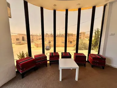 a room with chairs and a table and a large window at الفاخر للشقق الفندقيه in Al Mafraq