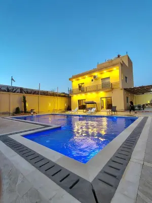a swimming pool in the backyard of a house at Janna2Villa in Tall al Misţāḩ