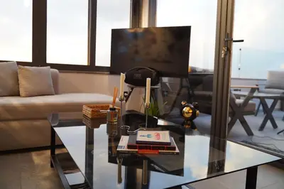 a living room with a glass table and a tv at Luxury Roof-top in Amman