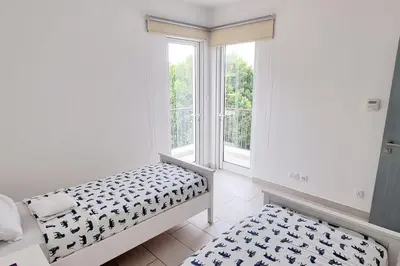 a white room with a bed and a window at Island Apartment in Aqaba