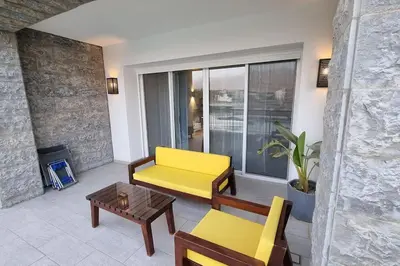 a living room with a yellow couch and a table at Island Apartment in Aqaba
