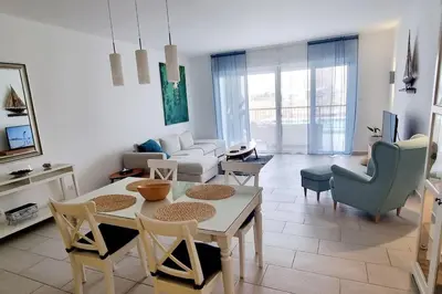a living room with a table and chairs and a couch at Island Apartment in Aqaba