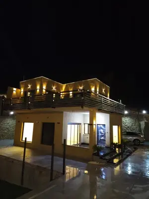 a building with lights on top of it at night at Sorjat Al Tal Chalet in Umm Tall