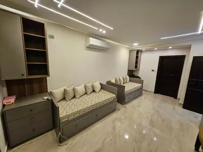a living room with two beds and a couch at Sorjat Al Tal Chalet in Umm Tall