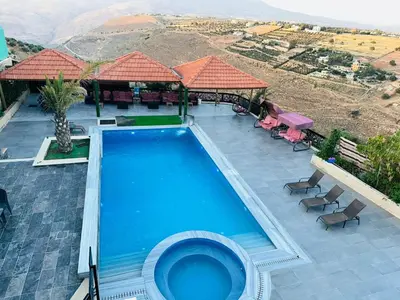 a swimming pool with a view of a mountain at The Royal Chalet in Ath Thukhaynāt