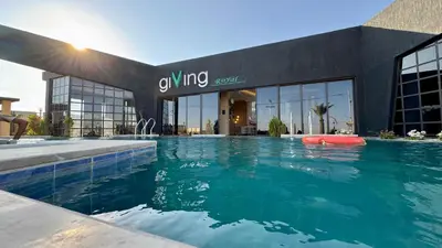 a large swimming pool in front of a building at Giving City in Amman