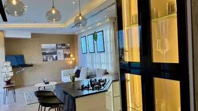 a kitchen with a stove and a living room at Giving City in Amman