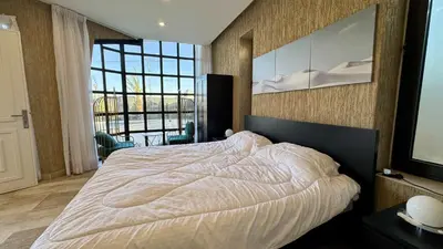 a bedroom with a large bed and a large window at Giving City in Amman