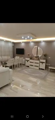 a living room with a table and a large mirror at Five-star hotel apartment in Amman