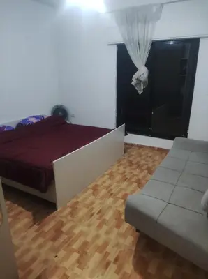a bedroom with a bed and a couch and a window at Amman in Amman