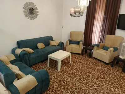a living room with blue couches and chairs at الخير شقق مفروشه in Al Jafr