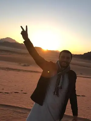 a man in the desert with his hand in the air at Wahj Ram camp in Aqaba