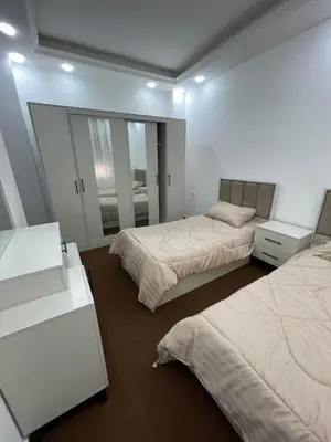 a bedroom with two beds and a mirror at Al Eman Oasis Farm in Jal‘ad