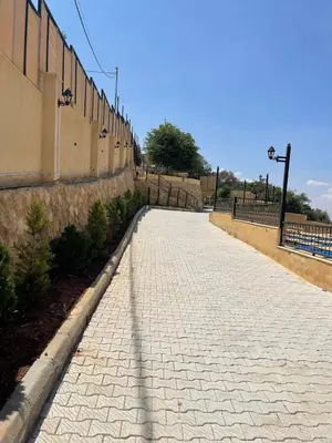 a brick road next to a wall with a fence at Al Eman Oasis Farm in Jal‘ad