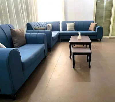 a living room with blue couches and a coffee table at Al Eman Oasis Farm in Jal‘ad
