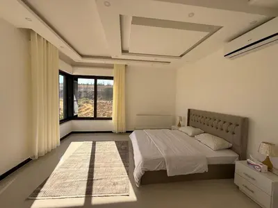 a bedroom with a bed and a large window at Dabouq 3BR condo in Amman