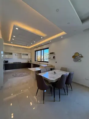 a kitchen and dining room with a table and chairs at Dabouq 3BR condo in Amman