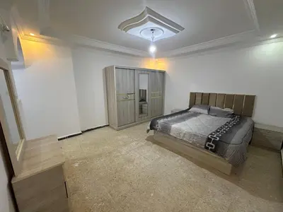 a bedroom with a bed in a white room at Beautiful apartment in Irbid
