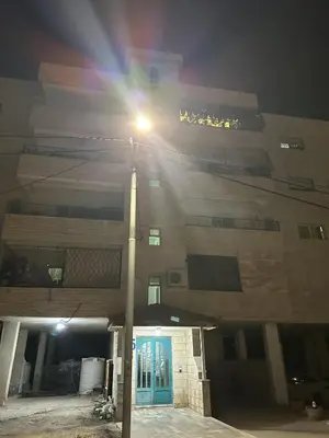 a street light in front of a building at night at Beautiful apartment in Irbid