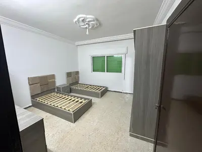 a room with two beds in it with a window at Beautiful apartment in Irbid