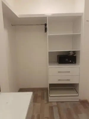 a room with a white closet with a microwave at Janty Apartments in Amman
