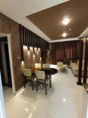 a dining room with a table and chairs and a couch at Janty Apartments in Amman