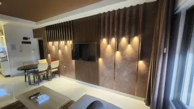 a living room with a table and a television at Janty Apartments in Amman
