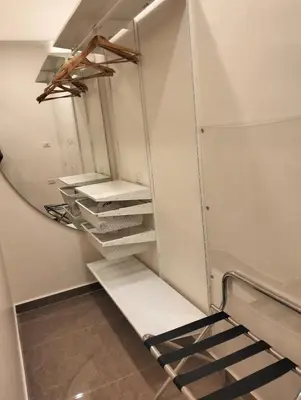 a walk in closet with a mirror and shelves at Janty Apartments in Amman